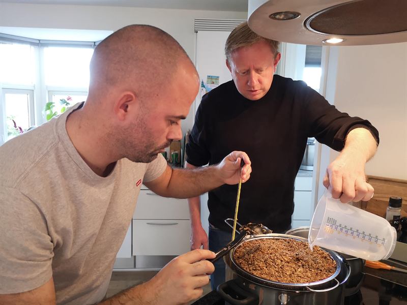 Hjemmebryg på køkkenbordet: gryde med malt, termometer og målebæger